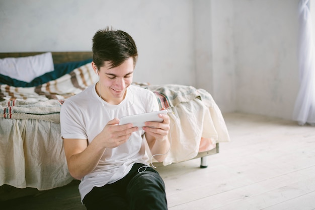 Handsome man surfing on tablet. Guy talking with friends, video conference, skype, tablet. The young student scrolls social networks