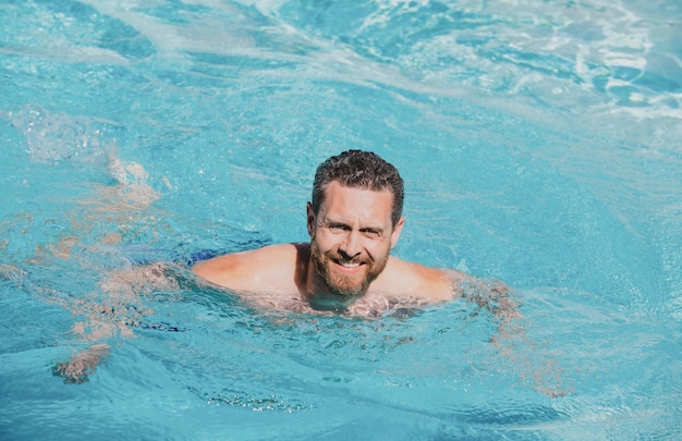 Handsome man in swimming pool pool party summer resort vacation concept