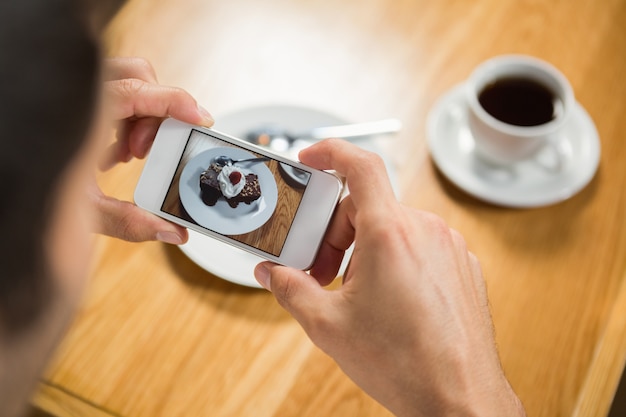 Handsome man taking a picture of his food