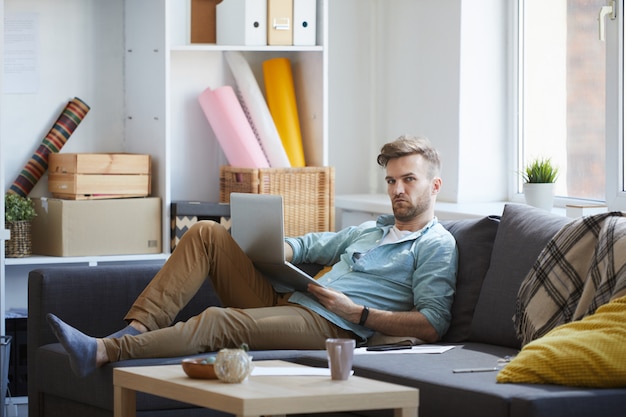 Handsome Man Using Laptop on Sofa