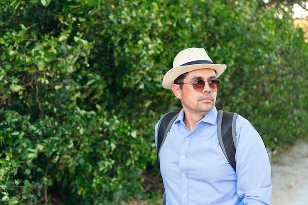 A handsome man walking with bicycle in the city. He is looking to the side