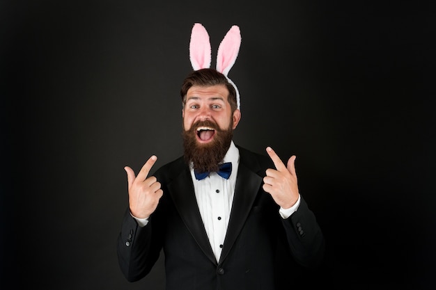 Photo handsome man wear bunny costume accessory. easter day. event host. celebrate easter. let me be your bunny. celebration easter holiday. bearded man with long ears. businessman with long ears.