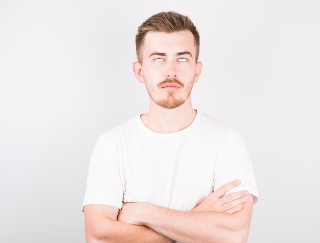 Handsome man in white shirt rolling eyes