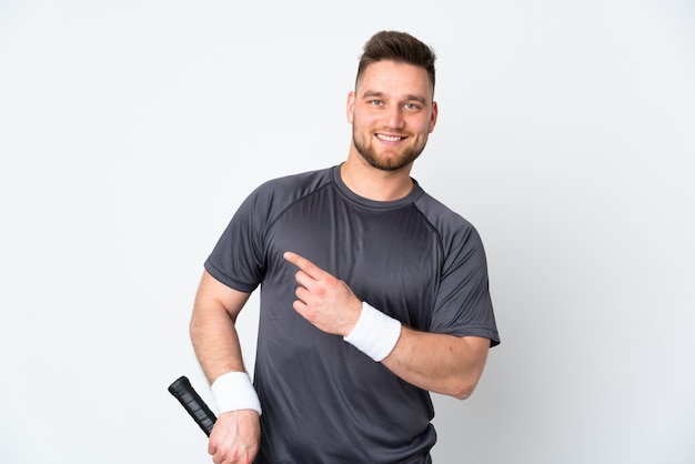 handsome man on white wall playing tennis and pointing to the side