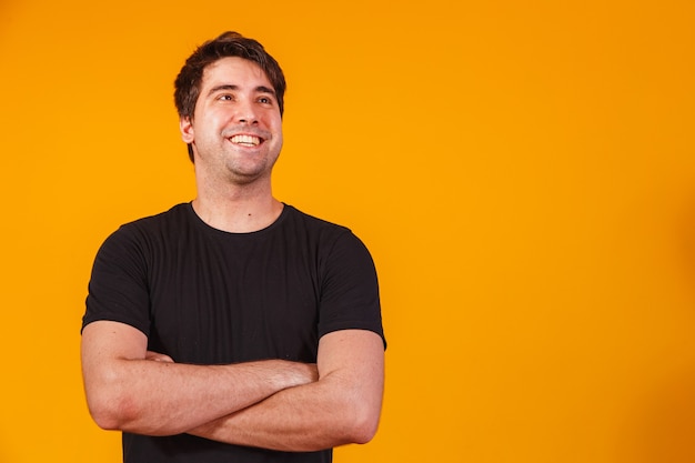 Handsome man with arms crossed on yellow