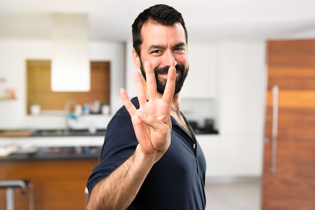 Handsome man with beard counting four inside house