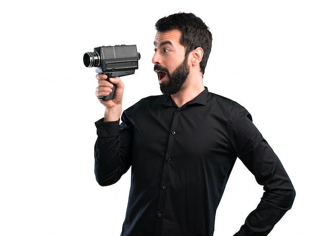 Handsome man with beard filming on white background