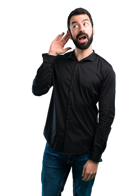 Handsome man with beard listening something on white background