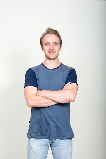  handsome man with blond hair against white wall