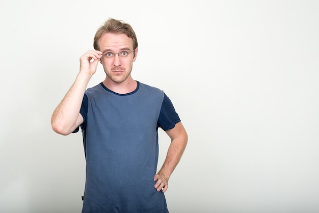 handsome man with blond hair against white wall