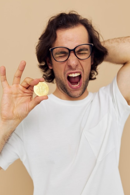 Handsome man with glasses gold bitcoin in hands isolated background