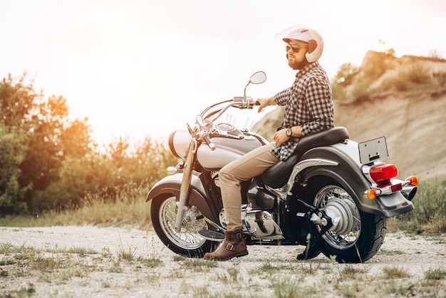 Handsome man with his moto in sand quarry