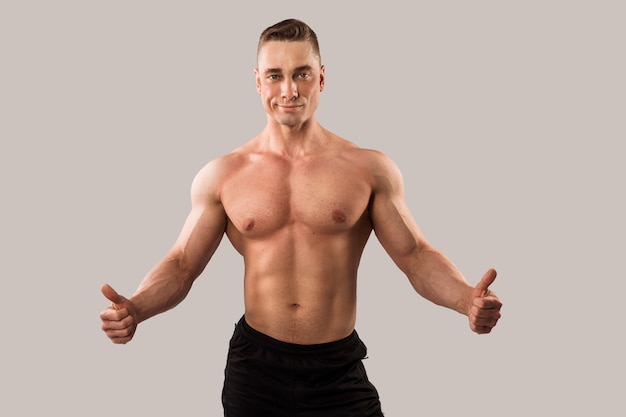 handsome man with muscles on gray background