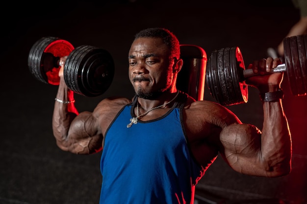 Handsome man with nice muscles hard working in the gym Sportsman working out his muscles