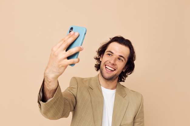 Handsome man with a phone in hand beige suit elegant style Lifestyle unaltered