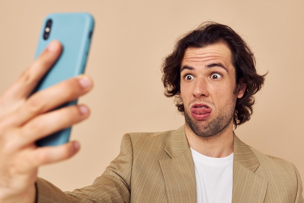 Handsome man with a phone in hand beige suit elegant style Lifestyle unaltered