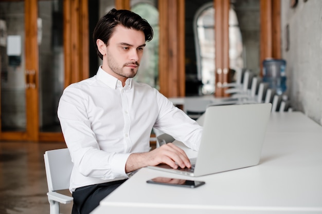 Handsome man working with laptop in the office