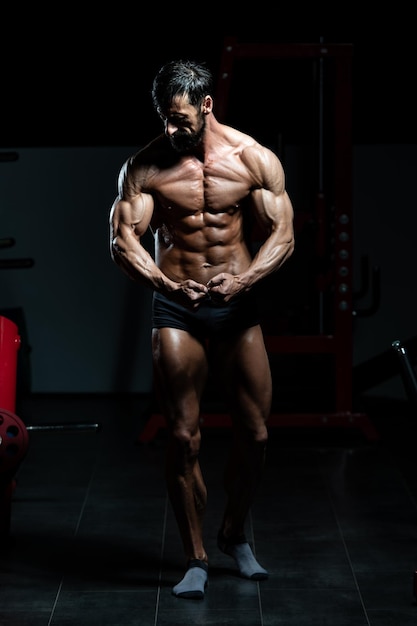 Handsome Mature Man Standing Strong In The Gym And Flexing Muscles - Muscular Athletic Bodybuilder Fitness Model Posing After Exercises