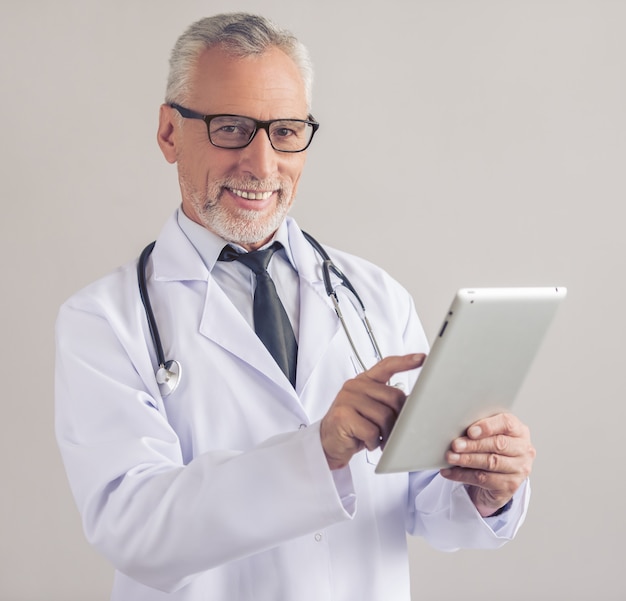 Handsome mature medical doctor in white coat.