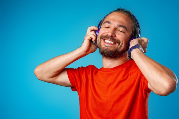 Handsome middle-aged man listening to music with blue headphones