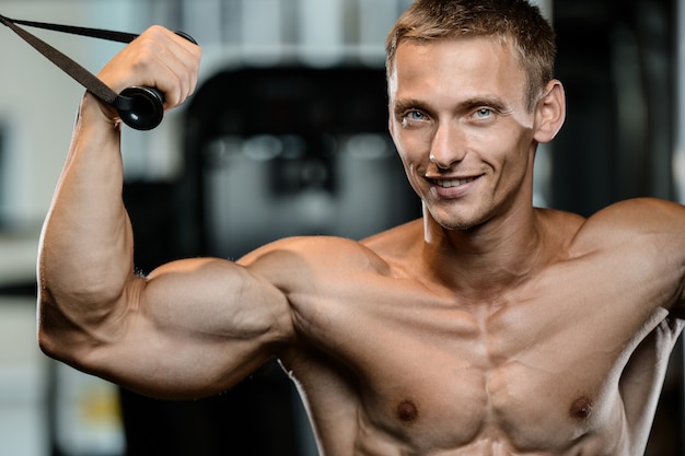 Handsome model young man working out in gym