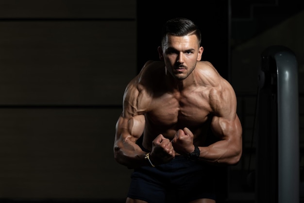 Handsome Muscular Man Flexing Muscles In Gym