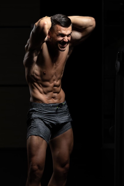 Handsome Muscular Man Flexing Muscles In Gym