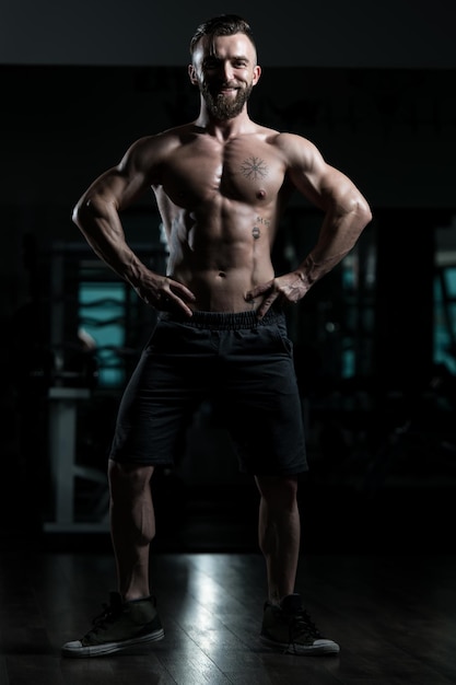 Handsome Muscular Man Flexing Muscles In Gym