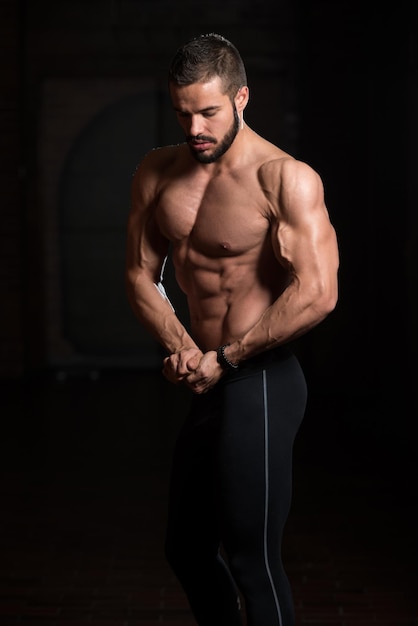 Handsome Muscular Model Flexing Muscles In Gym