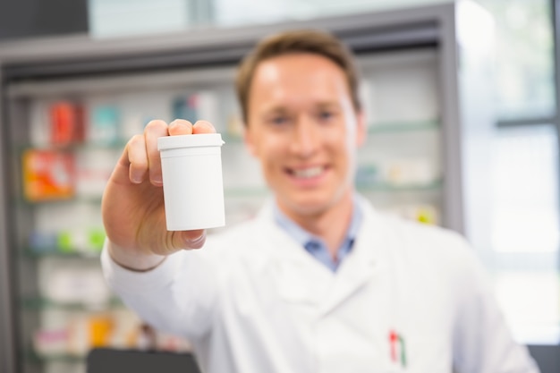 Handsome pharmacist showing medicine jar