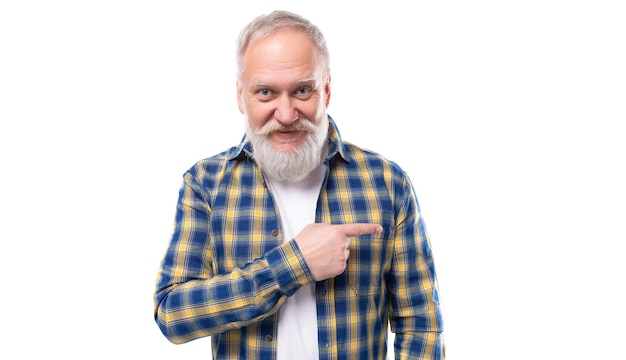 Handsome s elderly grayhaired man with a beard points his finger on a white background