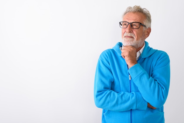 handsome senior bearded man thinking while looking up ready for gym on white