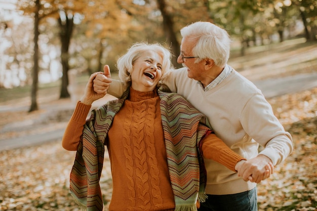 Photo handsome senior couple embracing in autumn park