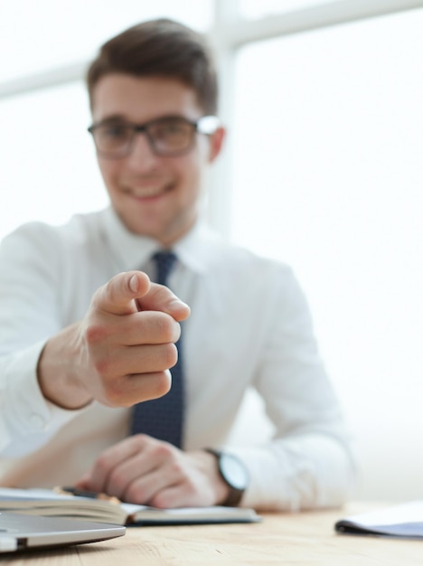 Handsome smiling businessman pointing his finger to you