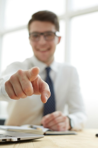 Handsome smiling businessman pointing his finger to you