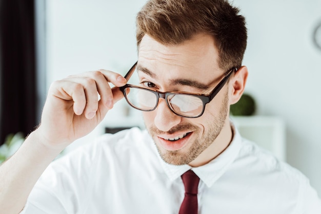 Handsome smiling businessman winking in glasses