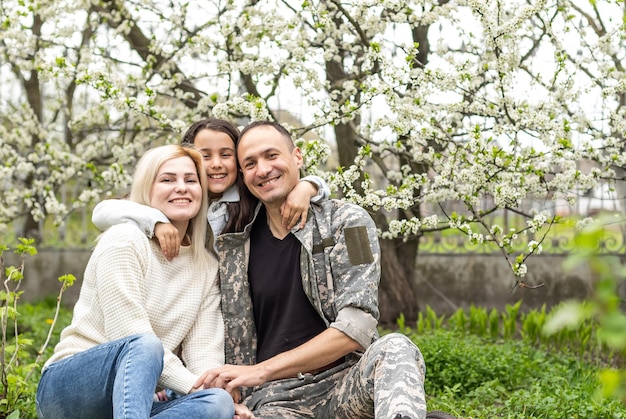 Handsome soldier reunited with family on a sunny day.