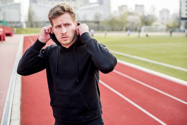 Handsome sport man wearing hoodie on race track