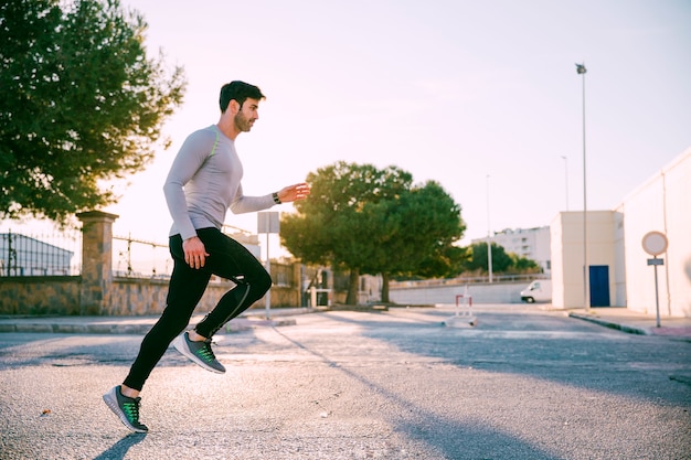 Handsome sportsman sprinting on street