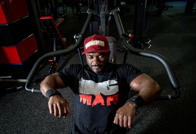 Handsome strong man training in the gym. Muscular fitness model resting in the gym.