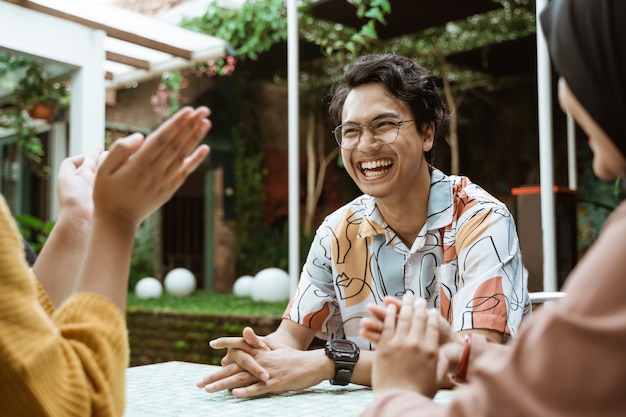 Handsome students laughing while chatting while hanging out