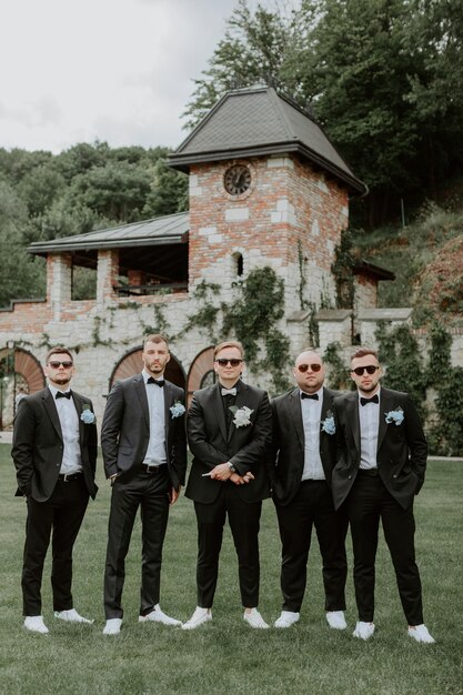 Handsome, stylish groomsmen and groom posing outdoors