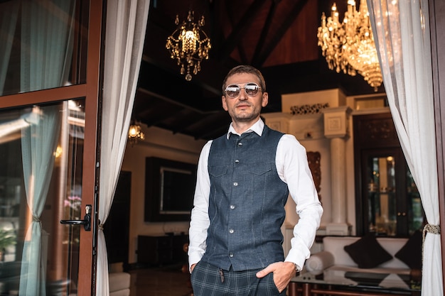 Handsome stylish young man model with glasses in fashion business clothes with suit