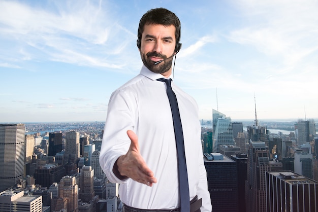 Handsome telemarketer man making a deal on unfocused background