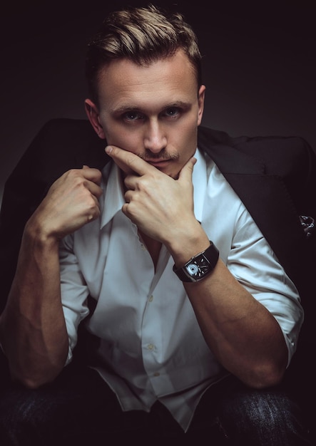 Handsome thinking  man in white shirt and black jacket on his shoulders