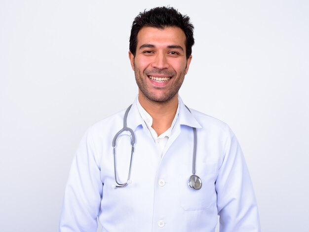  handsome Turkish man doctor against white wall