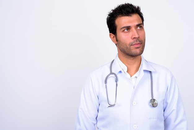  handsome Turkish man doctor against white wall