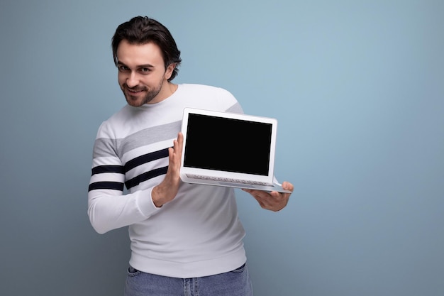 Handsome wellgroomed young brunette man showing advertisement on blank screen