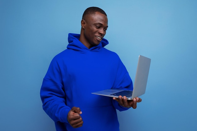 Handsome year old american businessman in stylish hoodie with laptop on background with copy space