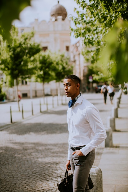 Handsome young African American businessman waitng a taxi in the street